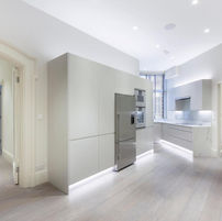 Contemporary kitchen renovation in London by Danko Construction Ltd with white, sleek-front cabinets, new flooring, renovated ceiling, updated electrical wiring, and modern plumbing