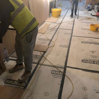 Work in progress at Leicester Square restaurant renovation with concrete flooring and wall preparation, highlighting meticulous preparation and high construction standards