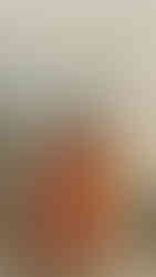 mulher negra de cabelos pretos cacheados tirando foto em frente a espelho sorrindo