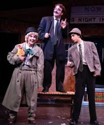Actress in a trench coat and beret with two actors in 1930s suits and hats, A Day in Hollywood, A Night in Ukraine