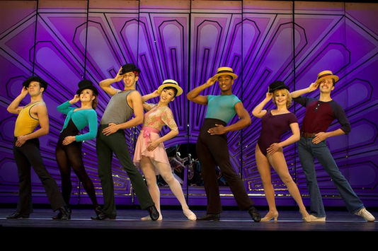 Dancers in rehearsal clothes and gold finale costumes in a kick line, A Chorus Line international tour