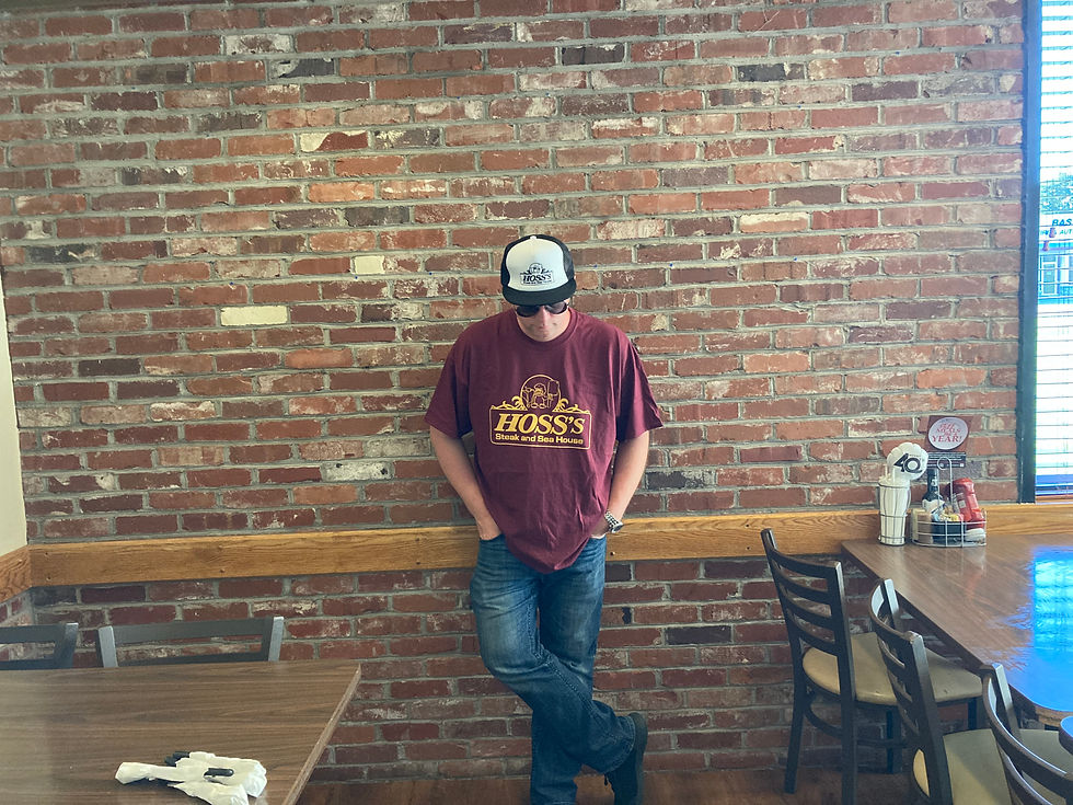 Man wearing Hoss's Steak and Sea House shirt and hat