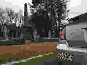 Ghostbuster bumper sticker on a Saturn Ion in a cemetery.