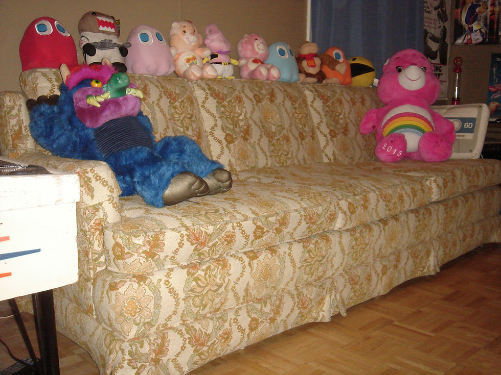 Cheer Bear Care Bear, My Pet Monster, Pac-Man, Donkey Kong, DragonBall Z plush toys on vintage couch.