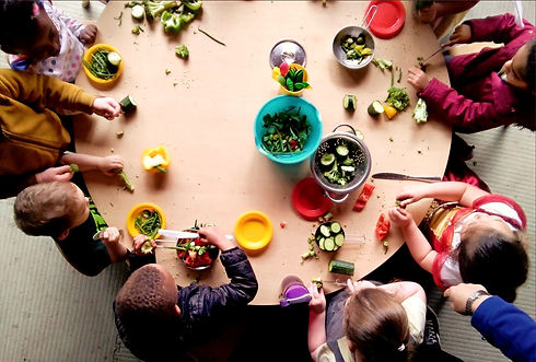 children around a table eating fruit