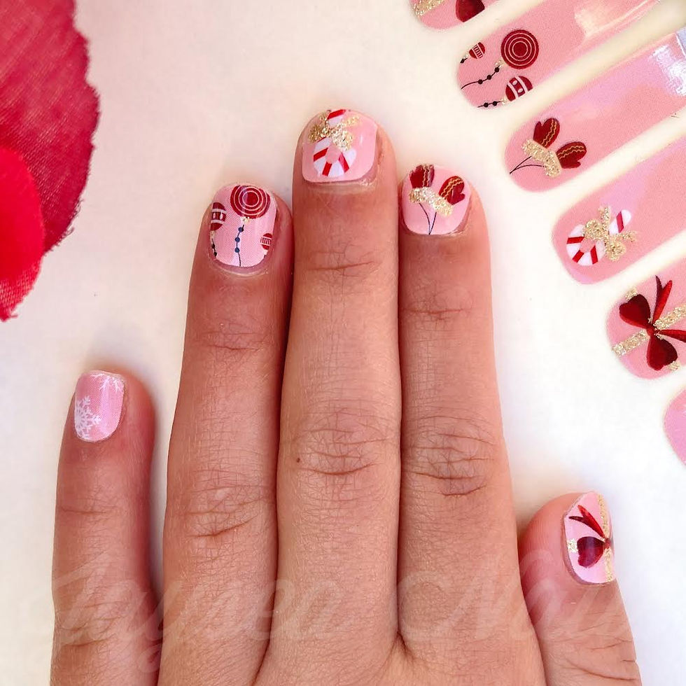 Cute child's nails showing off a pink Christmas manicures with candy cane, mittens, festive orngaments and snowflake nail art