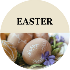 Delicate brown eggs painted with white designs in a bed of small purple flowers and leaves with the text "Easter" above 