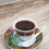Thumbnail: a cup of Ethiopian coffee with a sprig of garden rue