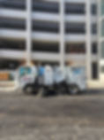DSS white Street Sweeping truck outside of a commercial building