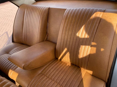 Gerestaureerd oldtimer interieur met bruin leren bekleding.