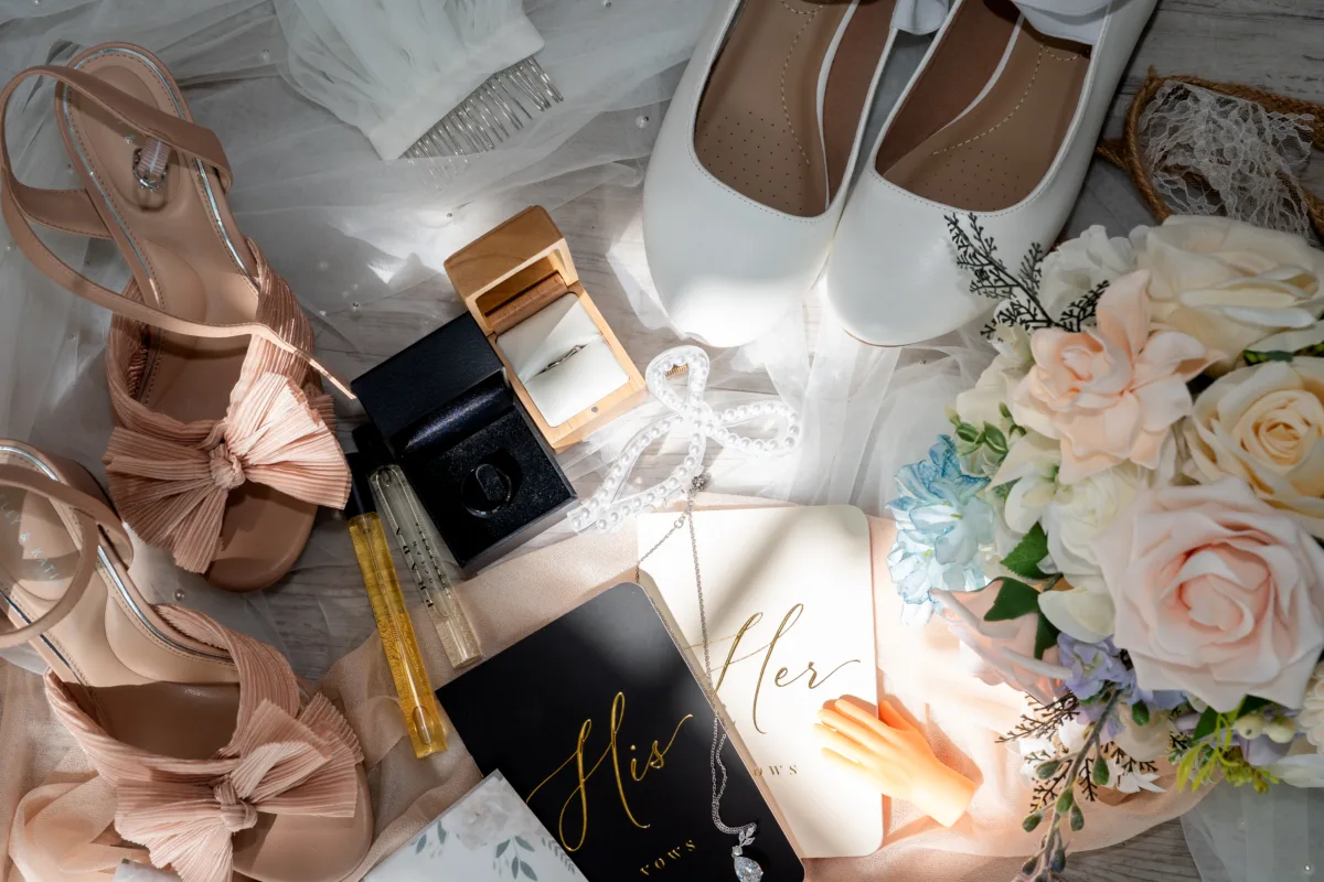 Wedding flat lay with shoes, invitation, rings, and bridal accessories