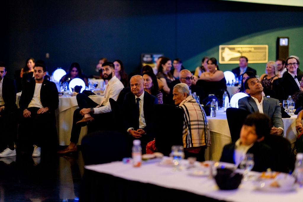 Guests watching the wedding reception program at decorated tables