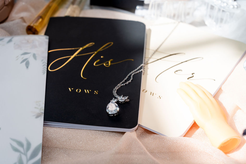 His and Her vow books with a teardrop pendant necklace