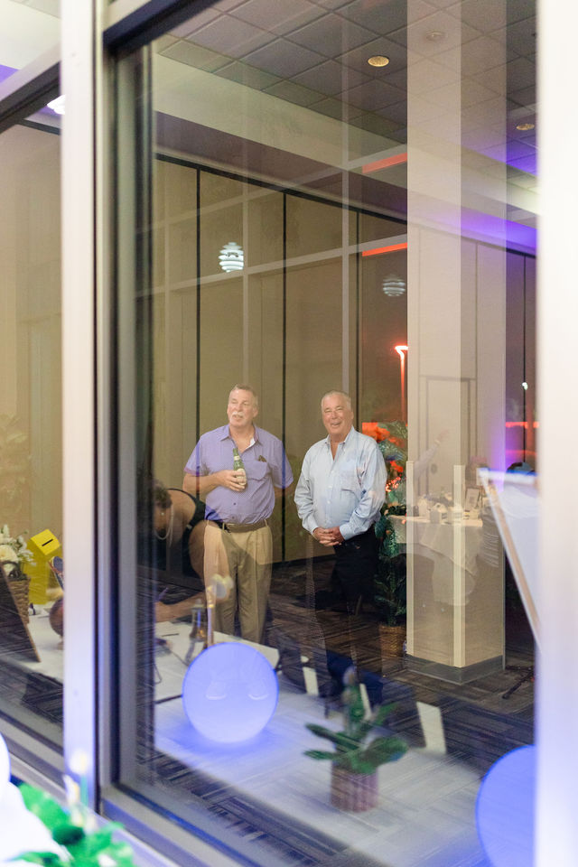 Adult guests standing by a window during the wedding reception