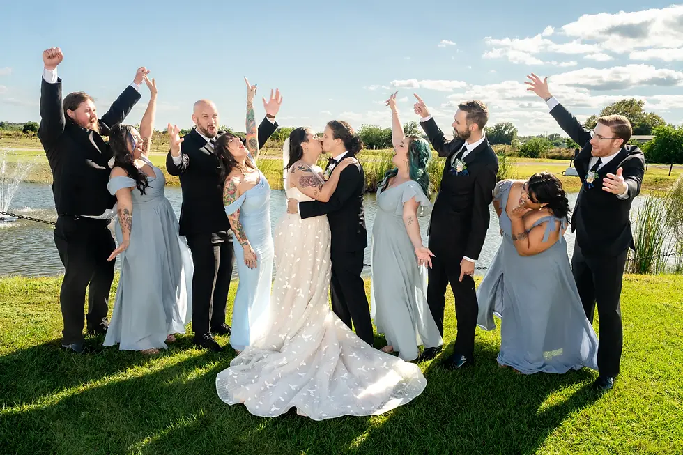 Bride and Groom kiss in the middle of cheering wedding party