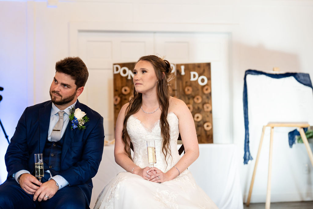 Bride and groom listening to speeches during their reception