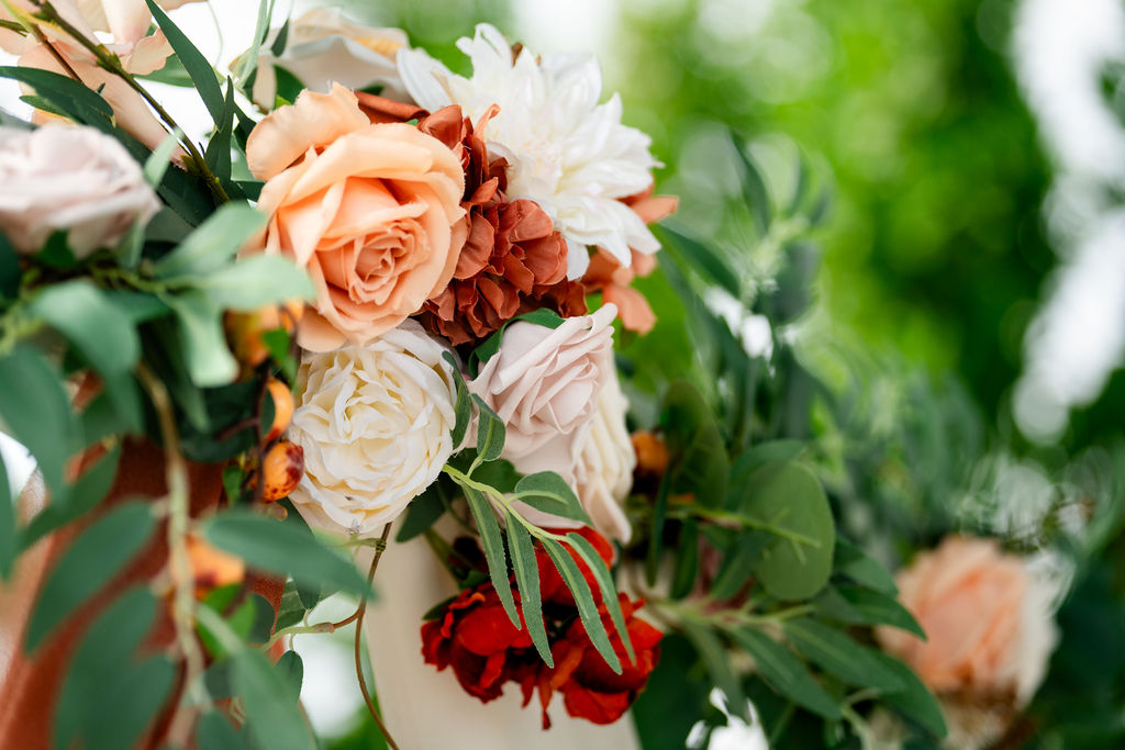 Close-up of peach, cream and burgundy wedding flowers