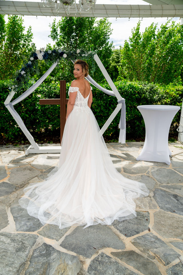 Bride showing the lace back and train of her wedding gown