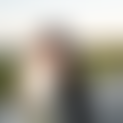 Bride and groom posing outdoors with bouquet near water at sunset during wedding day