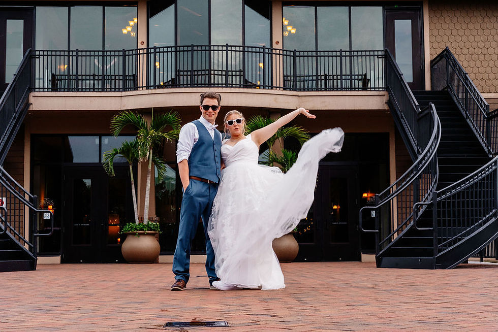 Bride tossing her wedding dress in the air while groom is laughing