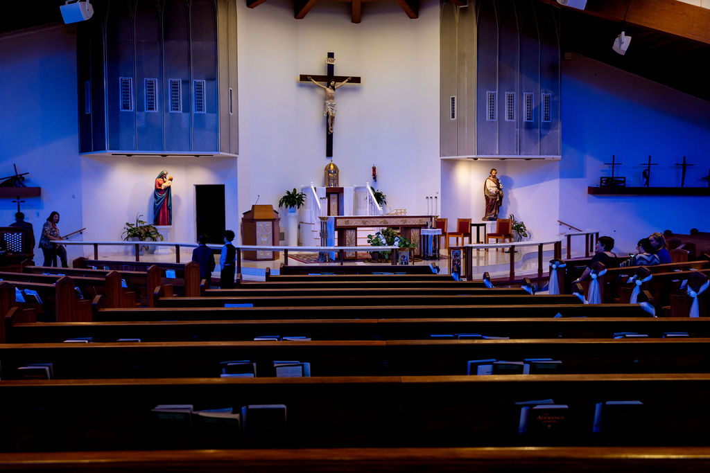 Church sanctuary with a crucifix, altar and candle arrangements