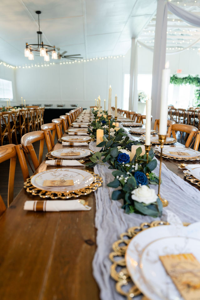 Long wedding reception table set with floral arrangements and gold-rimmed plates