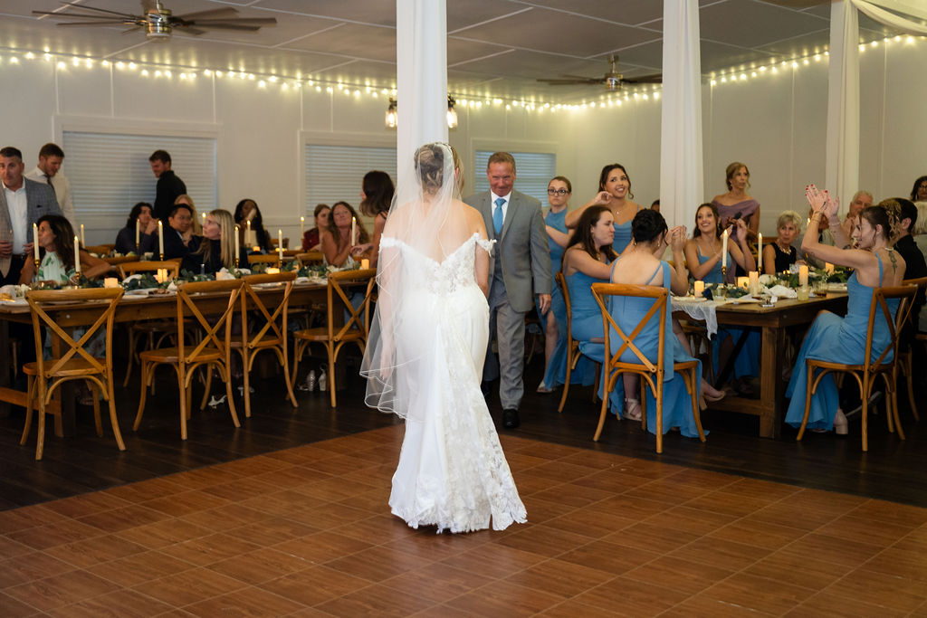 Bride walking across the reception dance floor toward her father