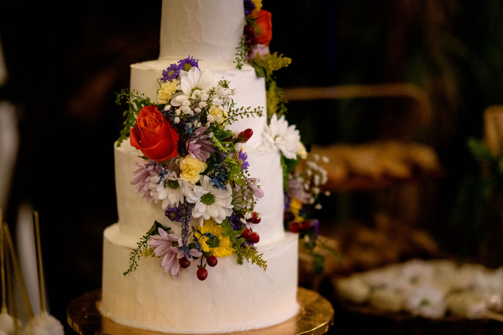 Tiered wedding cake decorated with colorful flowers