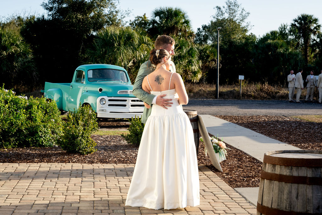 Bride posing beside a vintage turquoise pickup truck