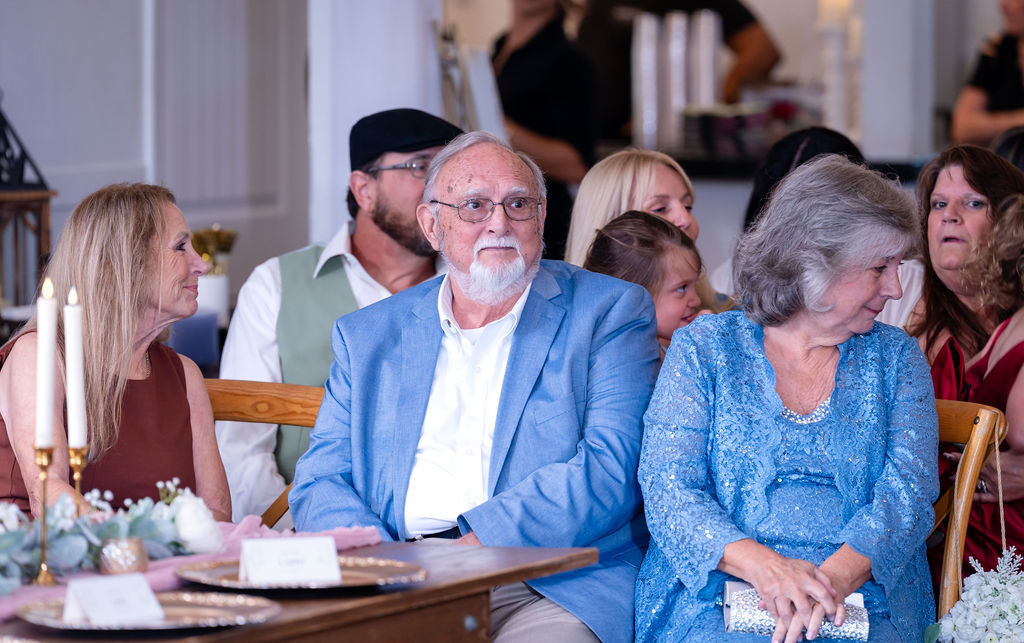 Two adult wedding guests seated together at the reception