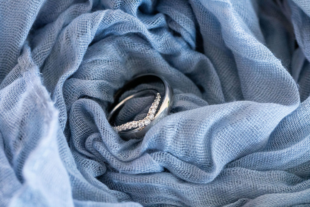 Two wedding rings nestled in folded pale-blue fabric