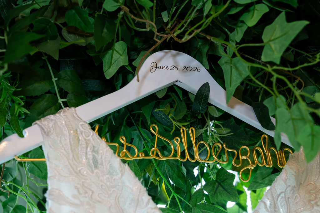 Personalized wedding dress hanger against greenery