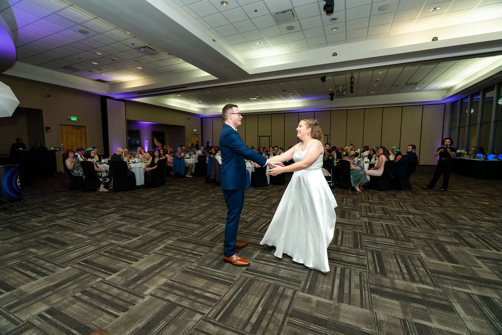Wide view of the bride and groom’s first dance with guests watching