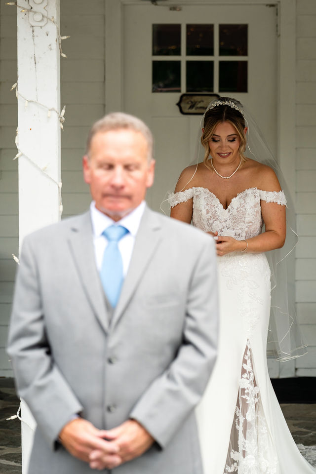 Bride standing behind her father before their first look