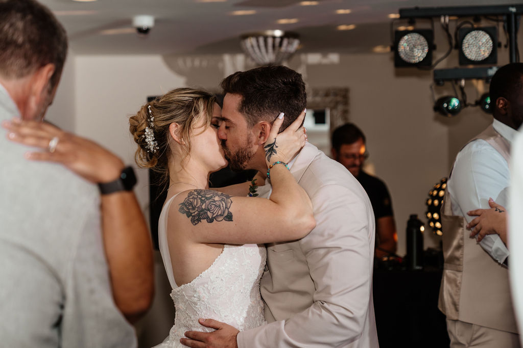 Bride and groom kissing on the reception dance floor