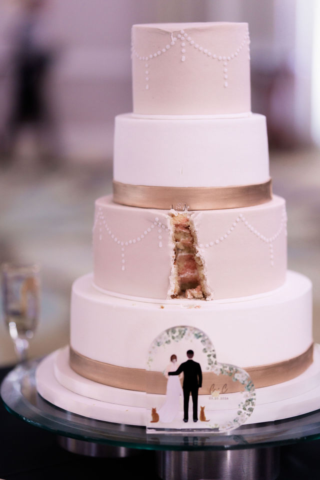 Minimal white tiered wedding cake with a gold accent