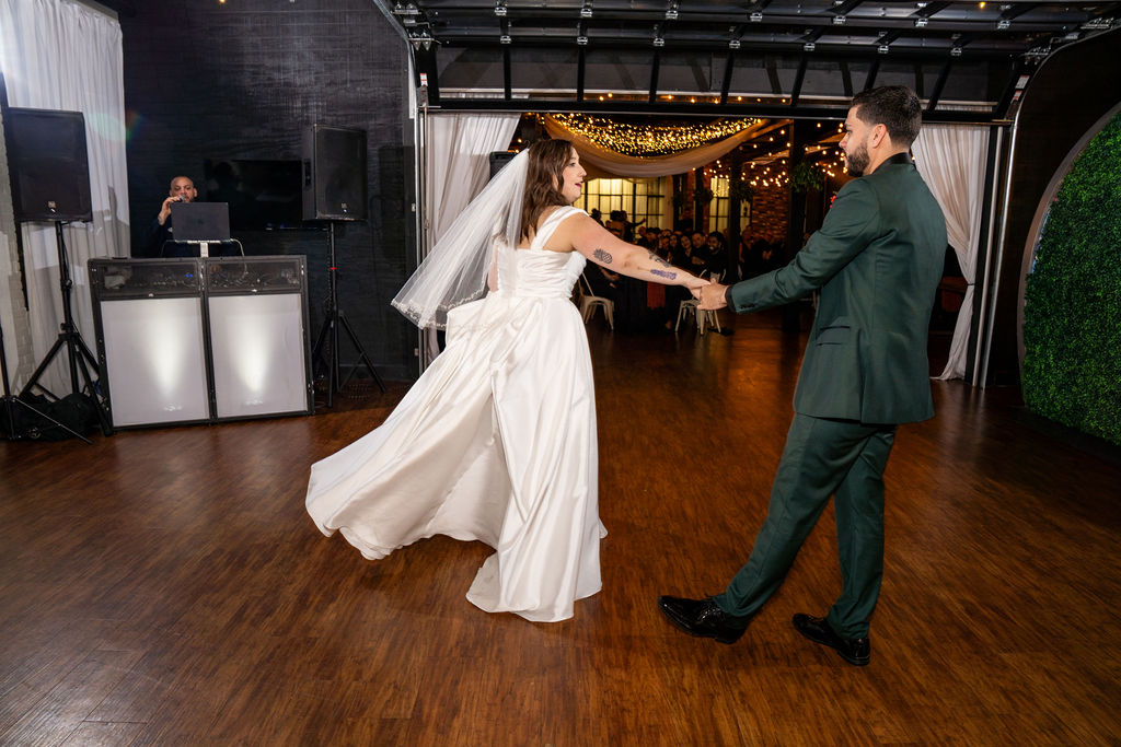 Bride and groom twirling on a spacious wooden reception dance floor