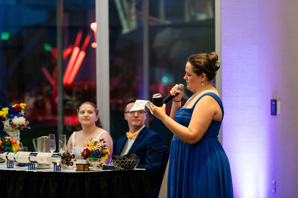 Bridesmaid delivering a wedding reception toast with a microphone