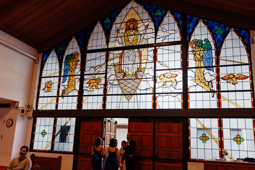 Stained-glass church entrance with colorful religious panels