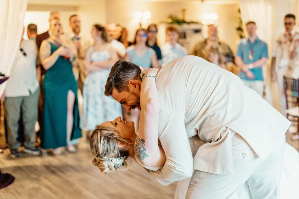 Groom dipping the bride for a kiss during their reception dance