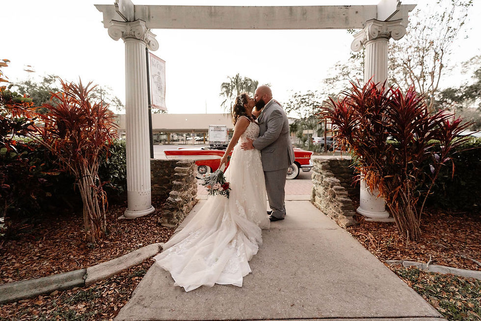 Bride and groom kissing under archway after ceremony