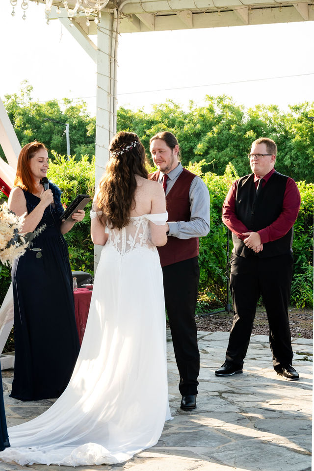 Bride and groom standing together during an outdoor ceremony