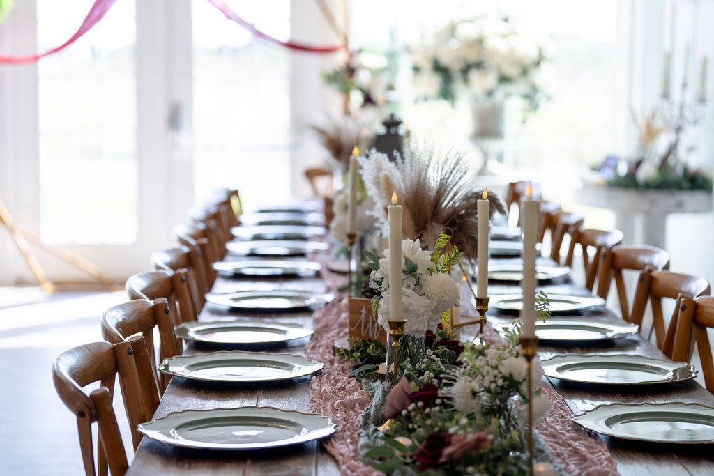 Long wedding reception table with place settings and floral centerpieces