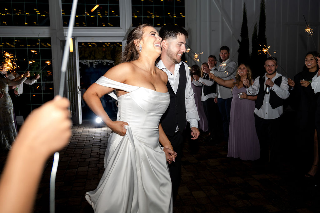 Bride and groom smiling as guests celebrate their wedding exit