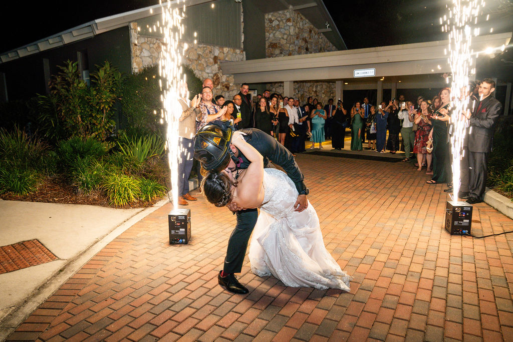 Groom dipping the bride between two fountains of wedding sparks