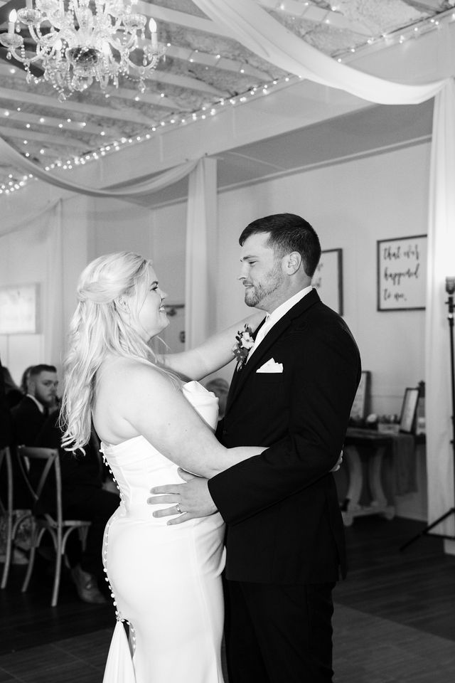 Bride and groom dancing together in a black-and-white photograph