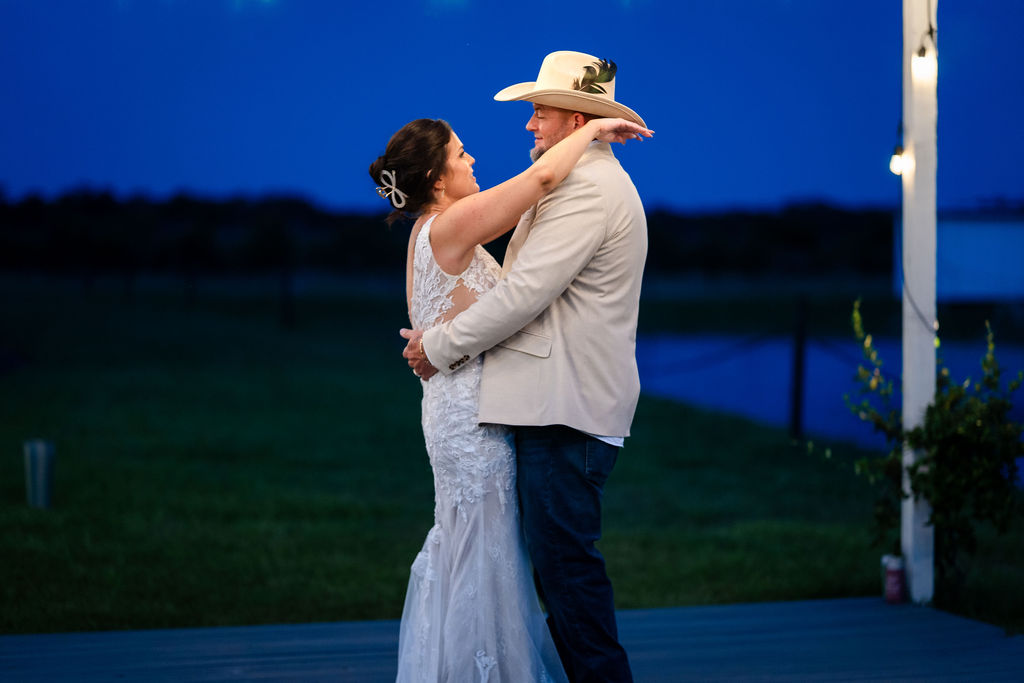 Bride and groom sharing a private dance outdoors at blue hour