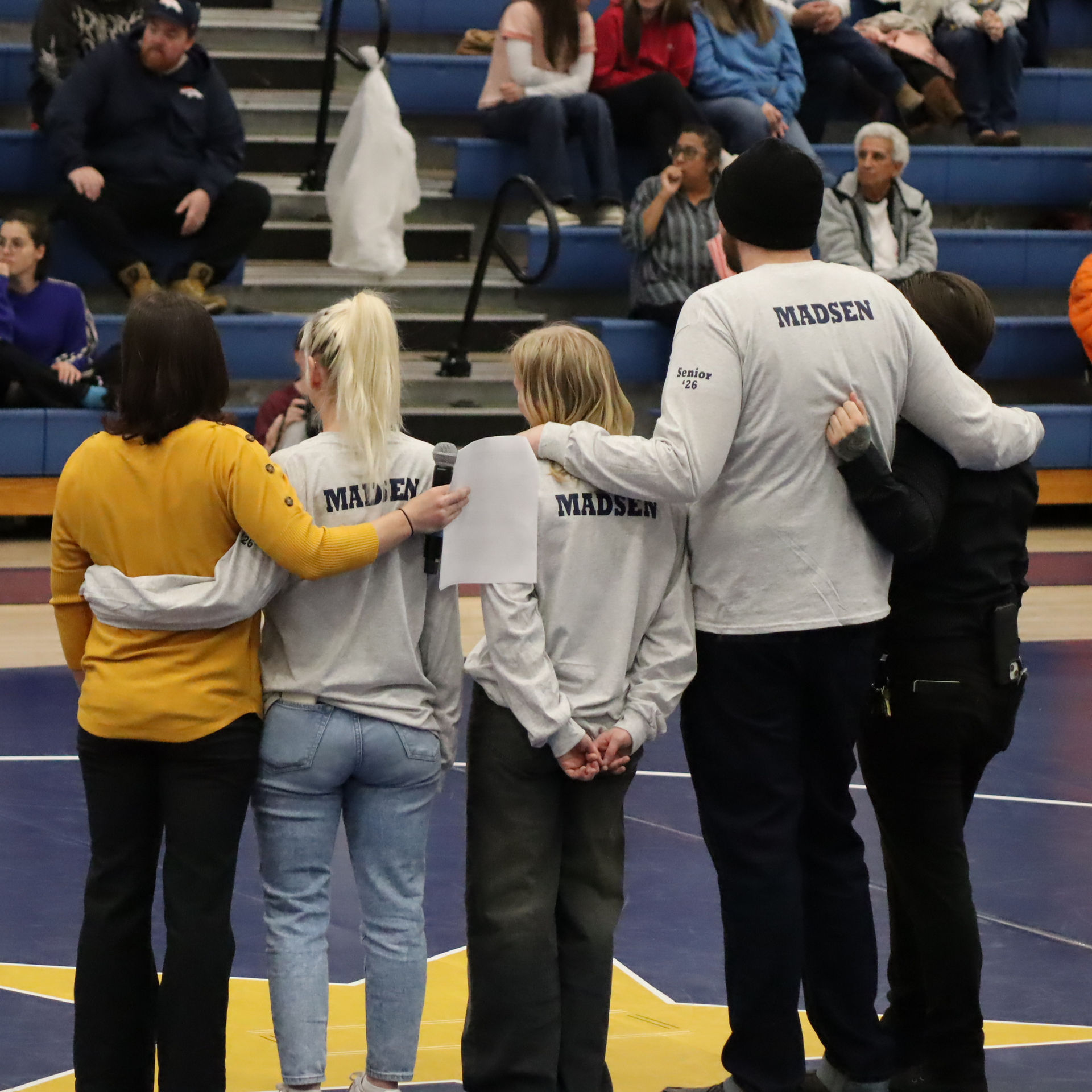 student with family and coaches taking a picture