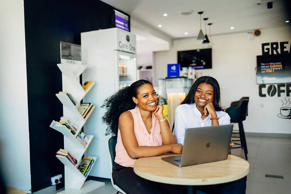 A pair of women in supervision, with relaxed posture in front of a shared laptop screen, caught on camera in a moment of engaged collaboration.