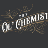 The Ol' Chemist logo on a dark background with decorative golden swirls.